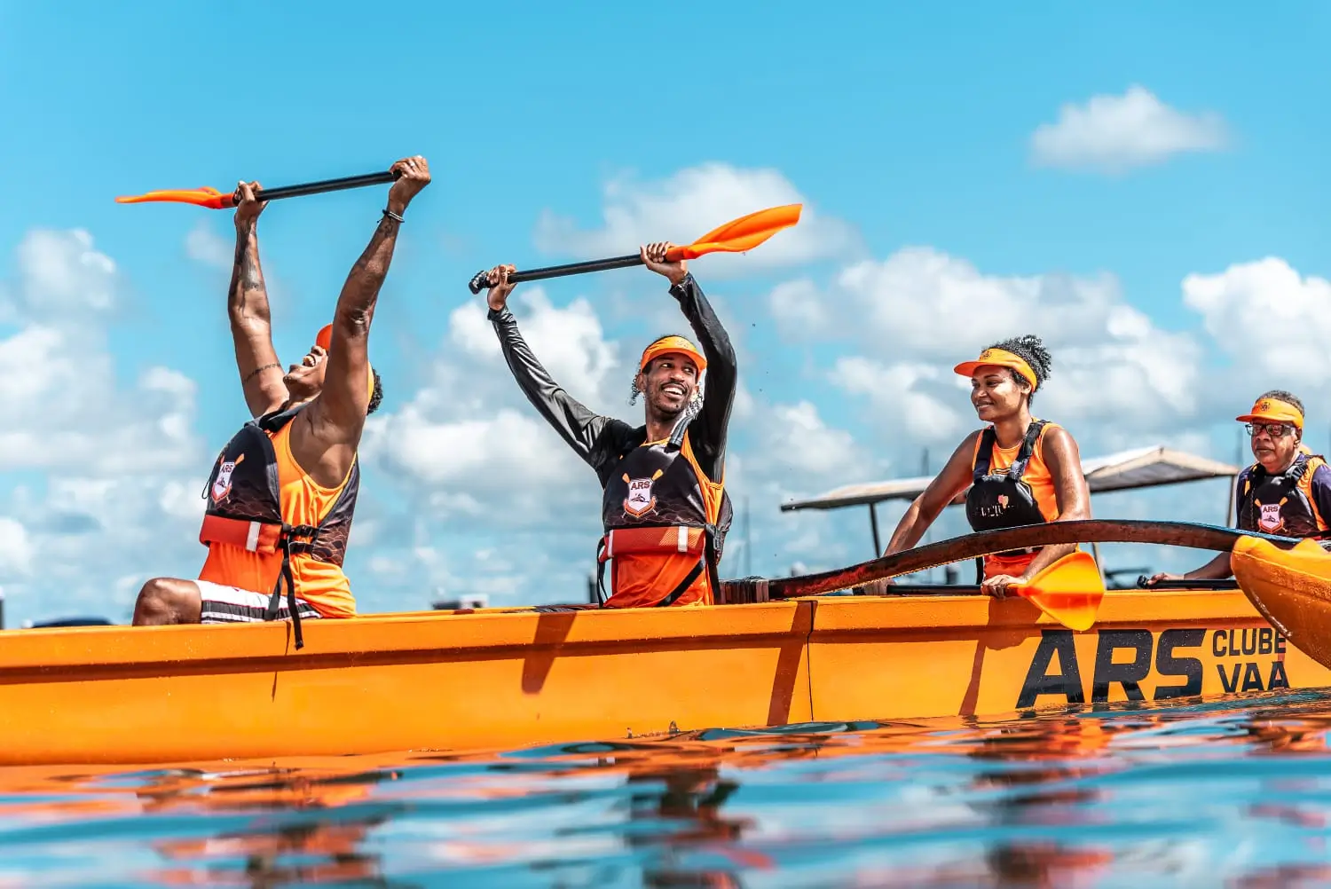 Equipe de atletas sincronizados remando juntos em uma canoa havaiana na Praia da Preguiça em Salvador